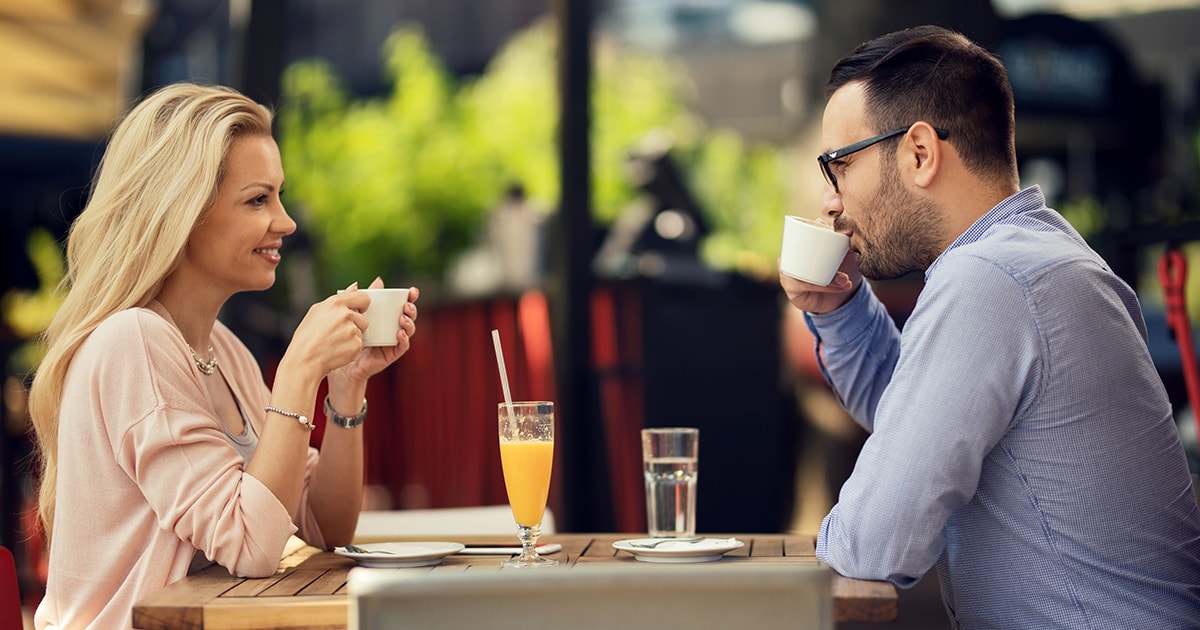 Lelki problémák szűrése randizás alatt Első randi egy kávézóban, egy férfi és egy nő egymással szemben ül és mosolyogva beszélgetnek